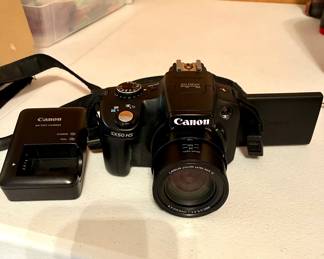 Canon Powershot SX50 HS. It is missing the lens dial but still auto focuses. It does have a battery and charger