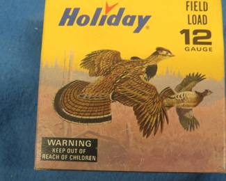 Lot 214. Vintage Holiday 12-gauge shotgun shell box with Les Kouba Ruffed Grouse and Rabbit in excellent condition. The box contains 25 9-shot shotgun shells in AA hulls which may be reloads. AS-IS. Use at your own risk.