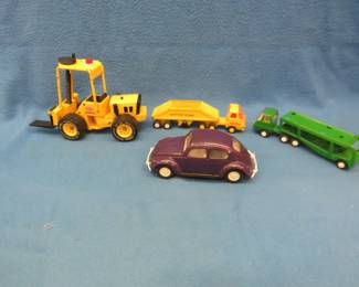 Lot 128. Four vintage pressed steel Tonka toys: 8 1/2" long Volkswagen Beetle marked #526980. Repainted. Forklift marked XR-101 on the tires. All parts work. Excellent condition. 11 1/2" long to the tip of the forks x 7" high to the top of the cab. Bottom dumper. 9 1/4" long x 2 1/2" high x 2" wide. Car hauler 9 1/4" long x 2 1/2" high x 2" wide. Repainted.