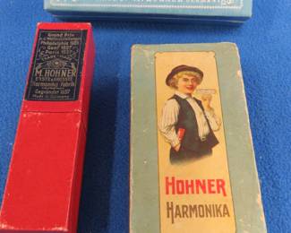 Lot 174. Three vintage empty Hohner harmonica boxes: Hinged 4 1/2" box in good condition. Two-piece box labeled Famous Terzett Koch-Harmonica in excellent condition. Hinged Marine Band Full Concert box in excellent condition