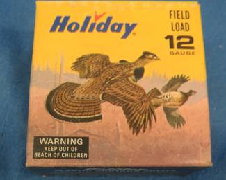 Lot 217. Vintage Holiday 12-gauge shotgun shell box with Les Kouba Ruffed Grouse and Rabbit in excellent condition. The box contains 25 9-shot shotgun shells in AA hulls which may be reloads. AS-IS. Use at your own risk.