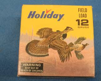 Lot 219. Vintage Holiday 12-gauge shotgun shell box with Les Kouba Ruffed Grouse and Rabbit in excellent condition. The box contains 25 9-shot shotgun shells in AA hulls which may be reloads. AS-IS. Use at your own risk.