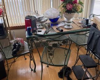Charming Wroutht iron indoor outdoor patio set with glass top and four chairs