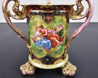 Lot #48 - Antique Hand-Painted Porcelain Wedding Cup Vase with Gilded Handles and Claw Feet – Romantic Classical Scene