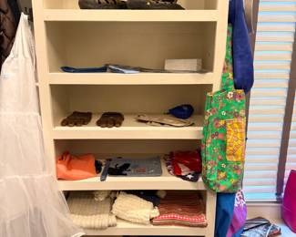 Organized closet with folded linens and handbags