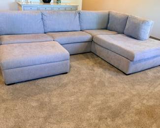 Large grey upholstered sectional sofa with chaise