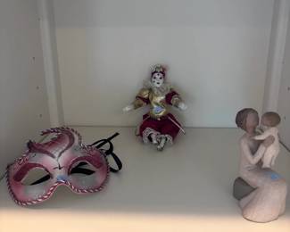 Decorative shelf: Venetian mask, jester doll, Willow Tree figurines