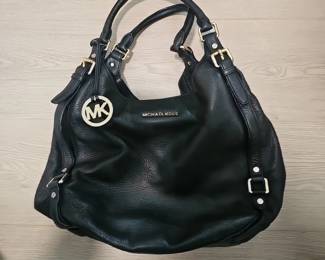 A black pebbled leather Michael Kors hobo shoulder bag with gold hardware.