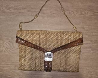 A vintage 1980s woven raffia clutch with snakeskin trim and chain strap.