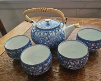 A Japanese blue and white porcelain tea set with a bamboo handle.