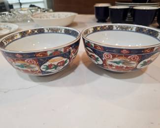 A pair of Japanese Imari porcelain bowls with floral and bird motifs.