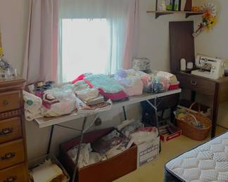 They're a bit tricky to see, but rolls of ribbon are here, behind the bedding on the table.