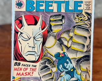 1965 Blue Beetle #4 published by Charlton Comics, featuring artwork by Steve Ditko. This vintage comic book has its original 12-cent cover price visible and showcases the key characters on the cover. Includes the tagline ‘BB Faces the Men of the Mask!’ 