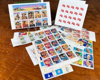 Unused United States postage stamps with a face value exceeding $50. The collection features various designs, including “Legends of the West” and other themed sheets depicting notable individuals, symbols, and events. All stamps are in original condition, ideal for collectors or practical use.