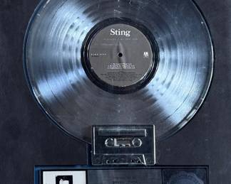 Platinum record plaque for Sting’s ‘Nothing Like the Sun, ’ presented to commemorate significant sales achievements. Features the album’s artwork, a platinum-finish record, and an integrated cassette tape. Measures 19.5” H x 16” W.