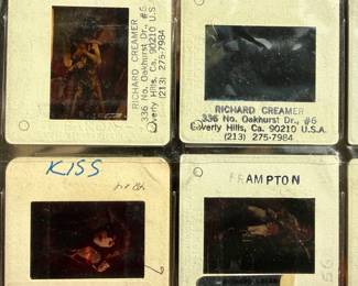Vintage 35mm slides primarily organized in a transparent holder. Each slide features labels with the name “Richard Creamer” and addresses in Beverly Hills and Los Angeles, CA. Subjects documented include notable music acts such as KISS, Ramones, Fleetwood Mac, and others. Handwritten annotations accompany several slides. Great condition for archival or display purposes.