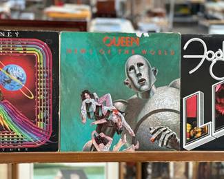 Three vinyl records featuring classic rock artists: Journey’s ‘Departure’, Queen’s ‘News of the World’, and Foghat’s ‘Live’. Album covers show light wear consistent with age and storage. Vinyl condition is not verified, and records are sold as-is. A great collection for fans of 1970s and 1980s rock music.