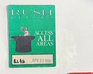 This lot features two (2) vintage All Access passes. The Rush pass features a green design with a rabbit emerging from a hat and is marked ‘APR 6, 1991.’ The R.E.M. pass is a red design from the ‘Green World Tour 1989,’ numbered ‘3/15.’ Both are collectible memorabilia from popular rock bands’ tours.