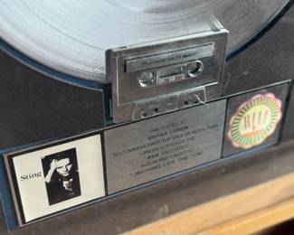 Platinum record plaque for Sting’s ‘Nothing Like the Sun, ’ presented to commemorate significant sales achievements. Features the album’s artwork, a platinum-finish record, and an integrated cassette tape. Measures 19.5” H x 16” W.