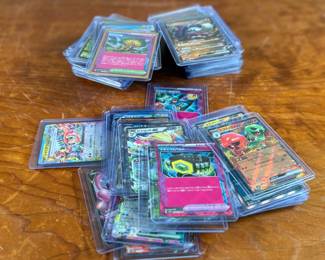 Lot consists of assorted Japanese Pokémon trading cards with holographic and full-art designs. Cards are stored in individual sleeves or protective cases.