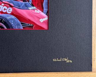 A photo collection of Mario Andretti and a signed ticket by Andretti. Photos taken by master photographer, Richard Stefani (also signed). Professionally matted and kept in a protective sleeve. Measures in matting, 17.25” H x 19.5” W. Mario Gabriele Andretti is an American former racing driver and businessman, who competed in Formula One from 1968 to 1982. Andretti won the Formula One World Drivers’ Championship in 1978 with Lotus, and won 12 Grands Prix across 14 seasons.
