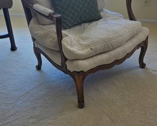 French Provincial chair with exposed carved wooden frame.