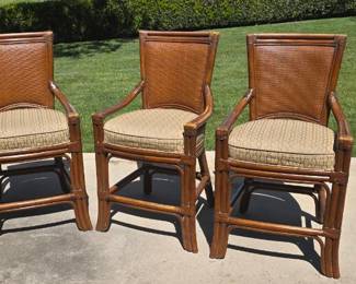 Three rattan wood-frame chairs with armrests.