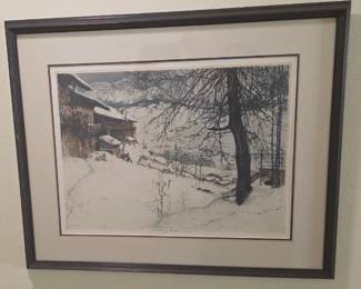 Framed artwork depicting a serene winter scene featuring a snow-covered chalet nestled against a mountain backdrop, with bare trees and soft light illuminating the pristine landscape.
