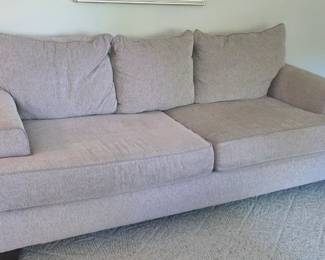 Contemporary three-seat sofa with down-stuffed cushions.