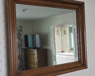 Wood-framed mirror with beveled glass.