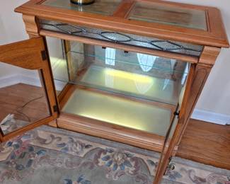 #71	Oak Entry Cabinet w/2 glass doors and 1 Glass Shelf w/leaded Décor accents w/glass Beveled Top w/light from Bottom Shelf w/ Matching Wood Mirror - 34x14x30  Mirror - 23x46	 $125.00 