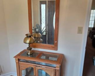 #71	Oak Entry Cabinet w/2 glass doors and 1 Glass Shelf w/leaded Décor accents w/glass Beveled Top w/light from Bottom Shelf w/ Matching Wood Mirror - 34x14x30  Mirror - 23x46	 $125.00 