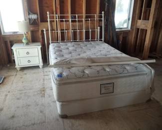 Queen bed with wrought iron heaboard & footboard; nightstand; table lamp