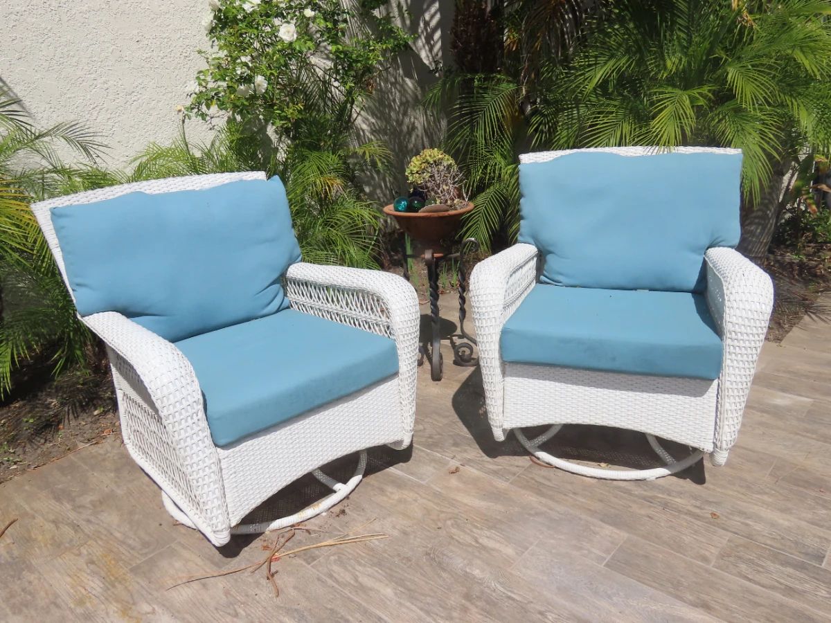 Two of four swivel resin patio chairs