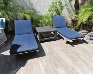 Two weathered teak sun loungers and cushions.