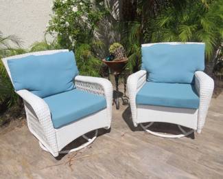 Two of four swivel resin patio chairs
