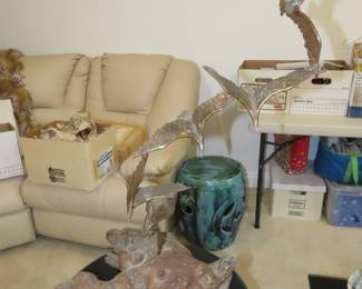 Brutalist flying bids sculpture on a knot of wood.