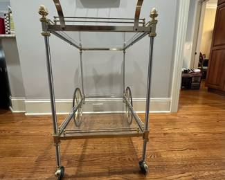 R82 - $450. French Bar Cart. Brass & Glass with finials. Rolls easily! Measures 36" x 20" x 33" tall. 