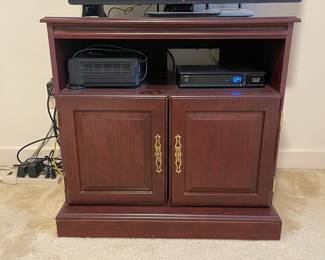 D9 - $35. Pressboard tv stand. Measures 24” wide x 19” deep x 28” tall. 