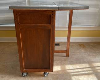 D16 - $150. Home Styles Rolling Kitchen Cart with storage and a drop leaf. Measures 43” wide x 20” deep x 35” tall. 30” deep with extension up.  Needs a little cleaning but very good condition!