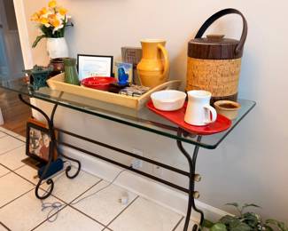 Glass top wrought iron console table with decor