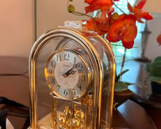 Brass anniversary clock with rotating pendulum