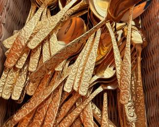 Gold-tone ornate flatware set in basket