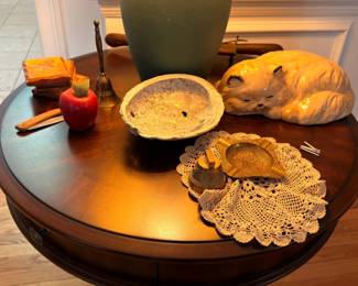 Round wood side table with ceramic cat and decor