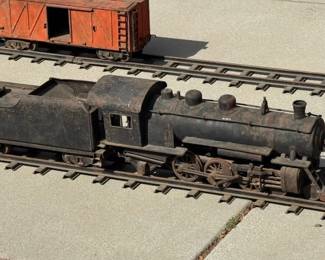 Buddy L  pressed steel Outdoor Railroad Set. Includes Locomotive, Tender, Cattle Car, platform for missing Wrecking Crane, and Caboose and track. All in original condition with play-wear. Locomotive measures 25"