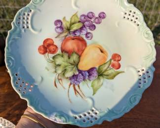 Antique plate w very detailed cutouts - it does have a chip near the wrist of the holder.