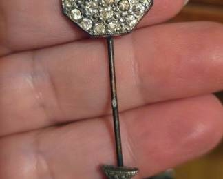Art Deco-style jabot pin or a vintage stick pin, featuring a decorative octagonal head covered in rhinestones or paste stones and an arrow-shaped tip