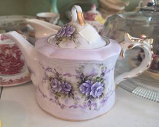 vintage Victorian-style teapot is a collectible musical porcelain item featuring delicate purple floral patterns and gold-tone trim.  Function: It is a musical teapot designed to play Beethoven's "Fur Elise". 