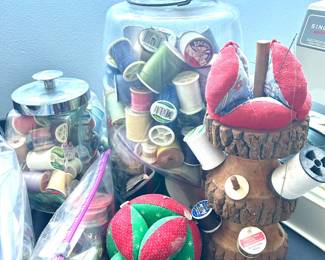 vintage jar with spools of thread, pin cushions 