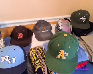 An assortment of hat baseball caps and bobblehead sports figures